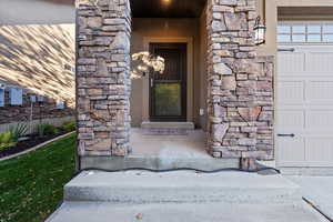 Property entrance with stone siding and stucco siding