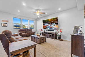 Living area with light carpet, a ceiling fan, and recessed lighting