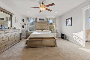 Bedroom featuring light carpet, multiple windows, ceiling fan, and recessed lighting