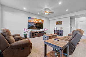 Carpeted living room featuring a ceiling fan and recessed lighting