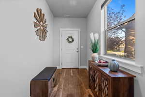 Foyer entrance featuring dark wood finished floors and baseboards