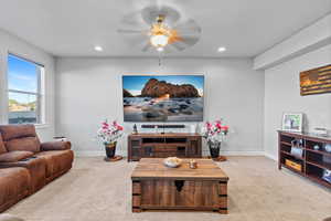 Carpeted living room with a ceiling fan and recessed lighting