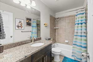 Bathroom featuring shower / tub combo, vanity, and light tile patterned floors