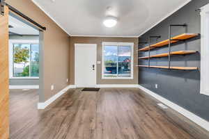 Entrance foyer with a barn door and dark wood-style flooring