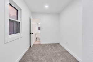 Unfurnished room with light colored carpet and baseboards