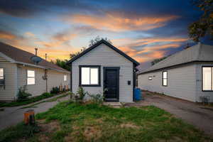 View of front of house featuring an outdoor structure and a front lawn