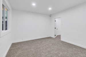 Carpeted spare room with baseboards and recessed lighting