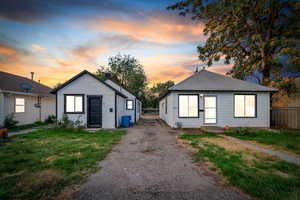 Bungalow-style house with a chimney, asphalt driveway, and a shingled roof