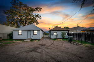 Back of property at dusk with a shingled roof