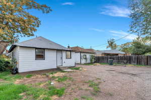 Rear view of property with entry steps and roof with shingles