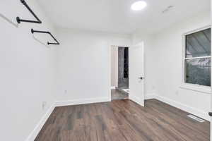 Empty room featuring dark wood-style floors and baseboards