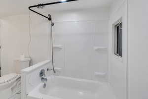 Bathroom featuring bathing tub / shower combination and toilet