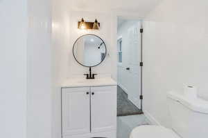 Bathroom featuring vanity and light marble finish flooring