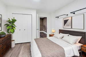 Bedroom with wood finished floors and a closet