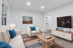Carpeted living room featuring baseboards