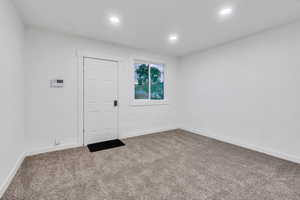 Carpeted empty room featuring baseboards and recessed lighting