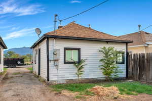 View of home's exterior with a mountain view and roof with shingles