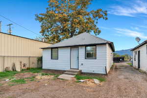 Back of property featuring roof with shingles and a mountain view