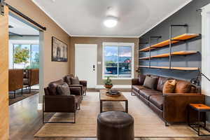Sitting room featuring a barn door, light wood-style floors, and ceiling fan