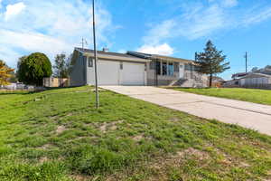 View of front of home with brick and siding, concrete driveway, and an attached garage