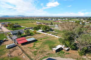 Aerial view of the property facing the rear of the property, including corral, barn and shop.