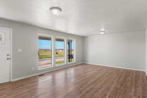 Unfurnished living room with a textured ceiling and light wood-style flooring