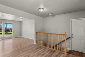 Unfurnished room featuring a textured ceiling and wood finished floors