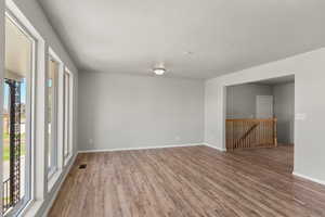 Empty room with light wood-style floors and a textured ceiling