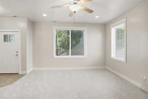 Unfurnished room featuring light carpet, recessed lighting, a ceiling fan, and light tile patterned floors