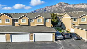 View of front of home with roof with shingles, a mountain view, stucco siding, and a residential view