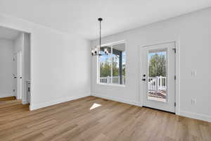 Unfurnished dining area with a chandelier and light wood finished floors