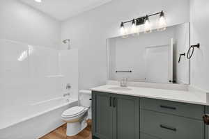 Bathroom with vanity, light wood-type flooring, and tub / shower combination