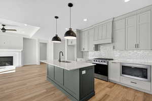 Kitchen featuring gray cabinets, appliances with stainless steel finishes, recessed lighting, decorative light fixtures, and decorative backsplash
