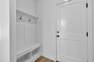 Mudroom with wood finished floors and baseboards