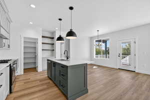 Kitchen featuring open shelves, pendant lighting, light stone counters, gray cabinetry, and white cabinetry