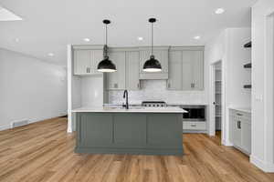 Kitchen featuring gray cabinetry, open shelves, recessed lighting, hanging light fixtures, and decorative backsplash