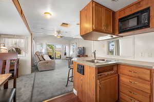 Kitchen featuring brown cabinets, a breakfast bar, open floor plan, and a peninsula