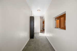 Hallway with carpet and baseboards