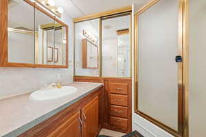 Bathroom featuring vanity and a shower stall