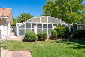 Back of house with a sunroom, a lanai, and a tile roof