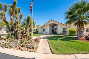 Mid-century modern home featuring a front lawn and stucco siding