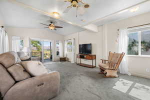 Carpeted living room with ceiling fan and baseboards