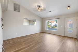 Foyer entrance with lofted ceiling, light wood-style floors, and a ceiling fan
