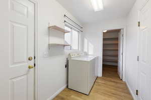 Laundry area featuring washer / dryer and light wood finished floors