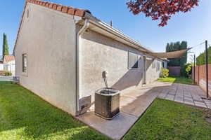 View of side of property with stucco siding, a patio area, and a fenced backyard