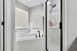 Full bathroom with a bath and a marble finish shower