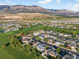 Aerial view of property and surrounding area with a mountainous background and nearby suburban area