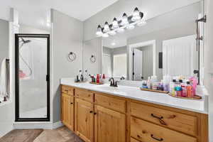 Bathroom with vanity, a marble finish shower, and light tile patterned floors