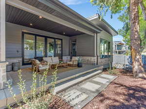 Rear view of property with an outdoor hangout area, a patio area, and stone siding