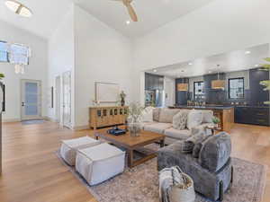 Living area featuring light wood-style floors, high vaulted ceiling, ceiling fan, and recessed lighting